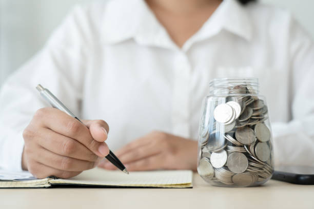 istock Woman with coins jar and checklist expenses doing accounting plan 1413582197