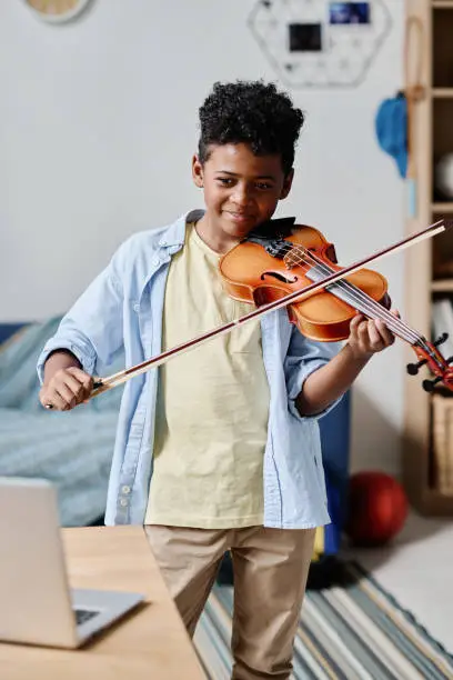 Photo of Boy learning to play musical instrument online