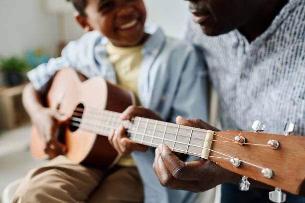 istock Boy learning to play guitar with teacher 1413582445
