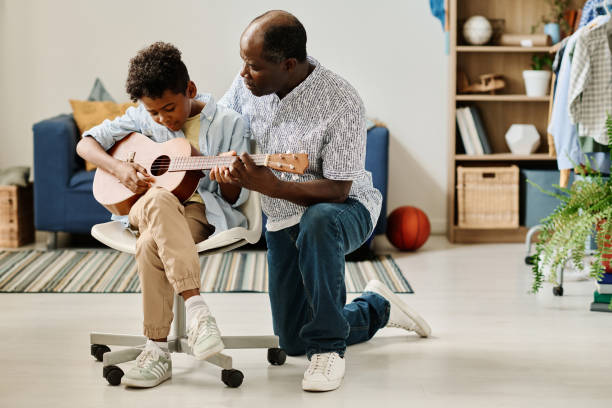 istock Teacher teaching boy to play guitar 1413582455