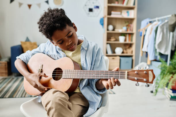istock African boy learning to play guitar 1413582460