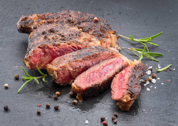 istock Grilled medium rare ribeye steak on gray stone plate. 1413583586