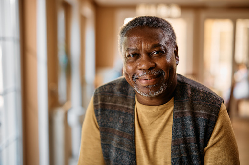 Portrait of happy African American senior man at retirement community looking at camera.