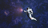 Astronaut spacewalk in space and touching orb of light.