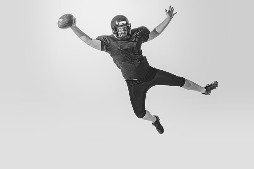 Winner, champion. Professional American football player posing at stadium in spotlights. Concept of movement and action, sport, lifestyle, competition.