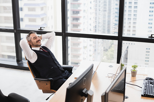 Relaxed man take break from work put hands behind head lean on comfy chair in the office.