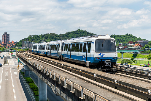 Taipei, Taiwan-July 5, 2020: Wenhu or Brown line of Taipei MRT in Taipei, Taiwan. View of a train running on the elevated track of the Taipei subway system under a clear blue sky.