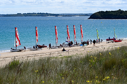 Saint-Cast-le-Guildo, France, July 4, 2022 - Group of teenagers learn catamaran sailing in the bay of Saint-Cast-le-Guildo, Brittany.
