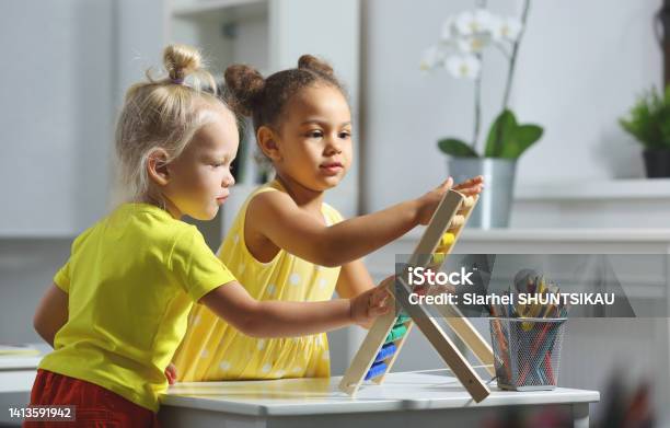 Children Of Different Races Sit Together At The Table And Count On The Abacus Stock Photo - Download Image Now