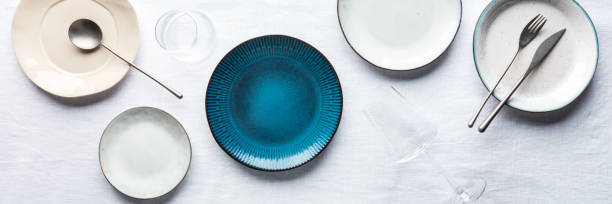 istock Modern tableware panorama with a vibrant blue plate, cutlery, and glasses 1413593489