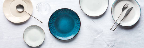 современная панорама посуды с ярко-синей тарелкой, столовыми приборами и стаканами - plate empty blue dishware стоковые фото и изображения