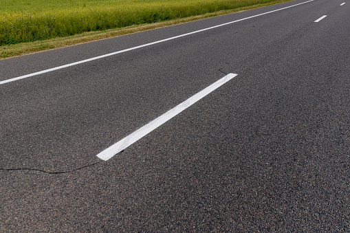 paved road for car traffic, road for vehicles with white road markings on the asphalt