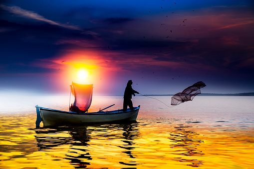 Fisherman fishing on the beach at sunrise, Konyaalti Beach, Antalya, Turkey