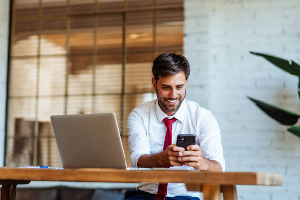 istock Businessman using smart phone and laptop and smiling 1413596472