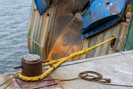Close-up view of cordage hanging on a commercial fishing trawler on a sunny day.
