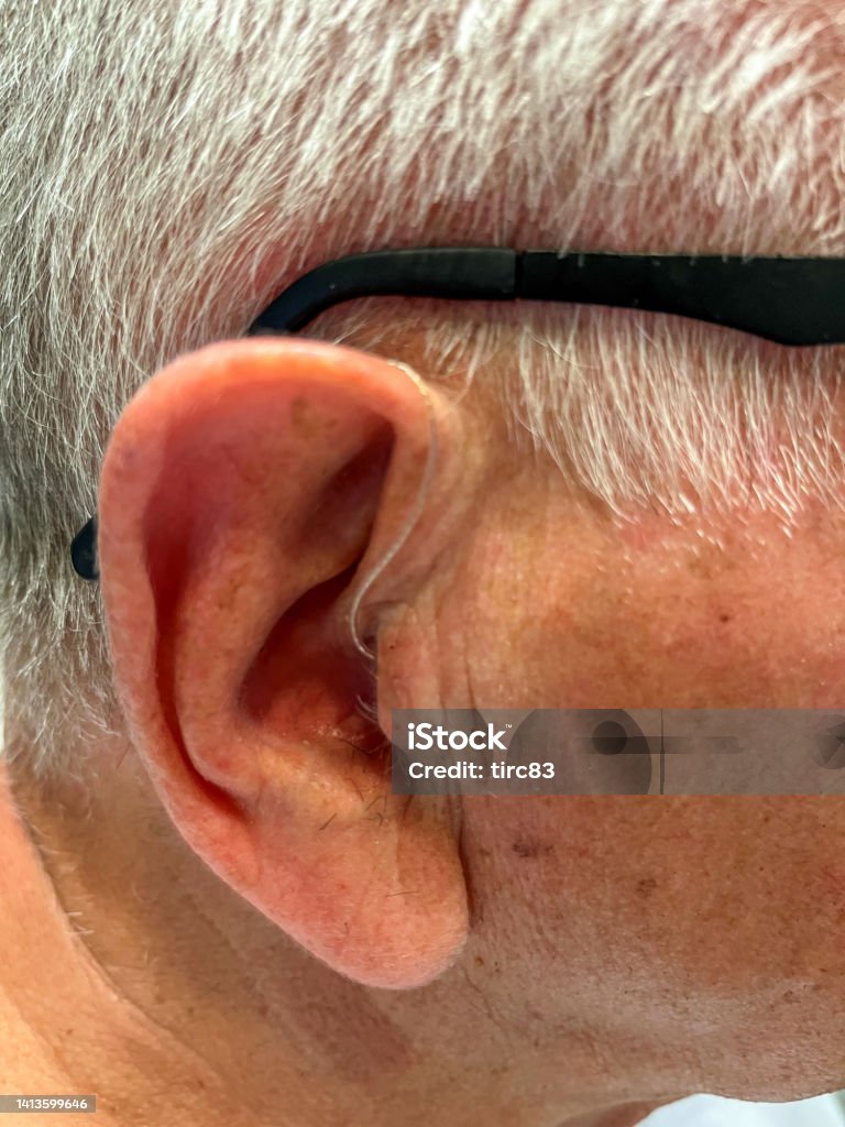 Senior man wearing hearing aid close-up 70-79 Years Stock Photo