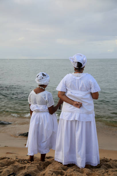 salvador, bahia, brazil - february 2, 2021: members of the Candomble religion are seen during an offering delivery to the orisha Yemanja on the Rio Vermelho beach in the city of Salvador.
