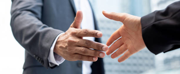Banner image of businessman hands making handshake in the city for merger and acquisition concept stock photo