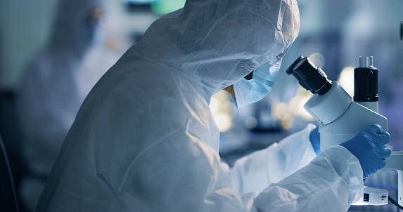 Científico, químico o ingeniero analizando la cura del covid en un laboratorio utilizando un microscopio. Investigar un virus y encontrar una cura a través de la ciencia y la innovación durante una pandemia photo