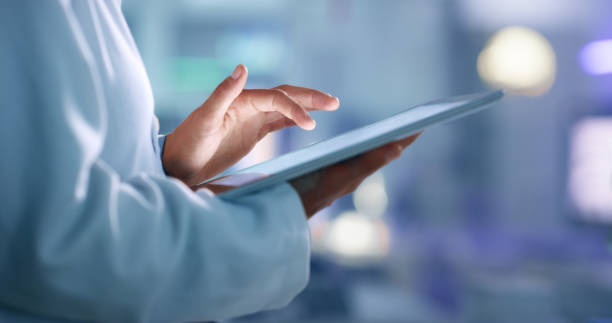 doctor, researcher or scientist browsing the internet on a tablet for information while working at a lab, science facility or hospital. expert, medical professional or surgeon searching the internet - health imagens e fotografias de stock