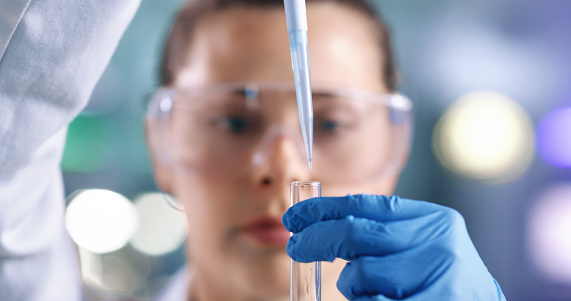 Phd scientist, forensic pathologist and medical researcher conducting experiments with a dropper and test tube in a lab. Closeup of an expert analyzing samples to develop a cure for a clinical trial