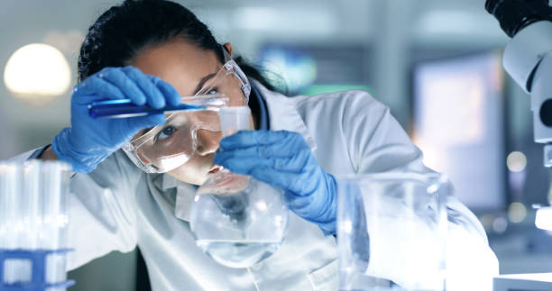 científico pensante, enfocado y profesional que investiga para crear una cura en un laboratorio de investigación. experto médico que utiliza equipos científicos en un laboratorio. trabajadora de la salud seria experimentando - women scientist indoors science fotografías e imágenes de stock