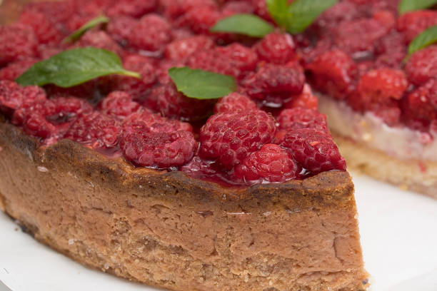 Tyrolean shortbread cheesecake with raspberries cut in white plate