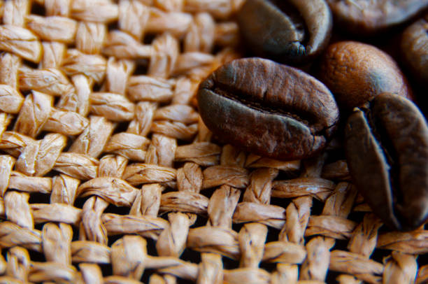 Close up of coffee beans on brown sack with customizable space for text or ideas. Copy space