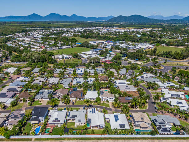 vista aérea del suburbio establecido de cairns, espacio verde de reserva, palmeras tropicales y rangos en la distancia - cairns fotografías e imágenes de stock