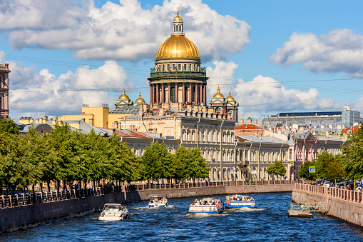 St. Isaac's cathedral and cruise boats on Moyka river, Saint Petersburg, Russia