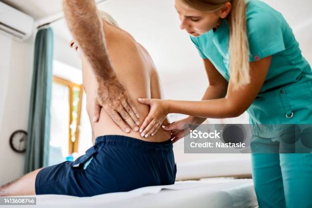 Young Physiotherapist Working On Back Pain Stock Photo - Download Image Now - Backache, Doctor, Patient