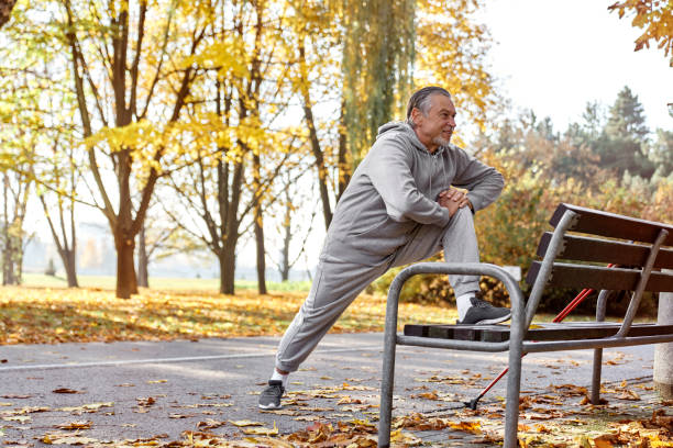 Senior caucasian man stretching in the park stock photo