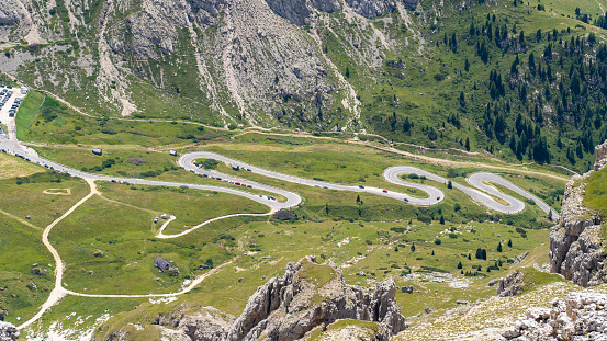 Road to the Pordoi mountain pass in Italy. Amazing aerial view of the mountain bends creating beautiful shapes. A famous route of the Italian Alps. Dolomites Unesco world heritage