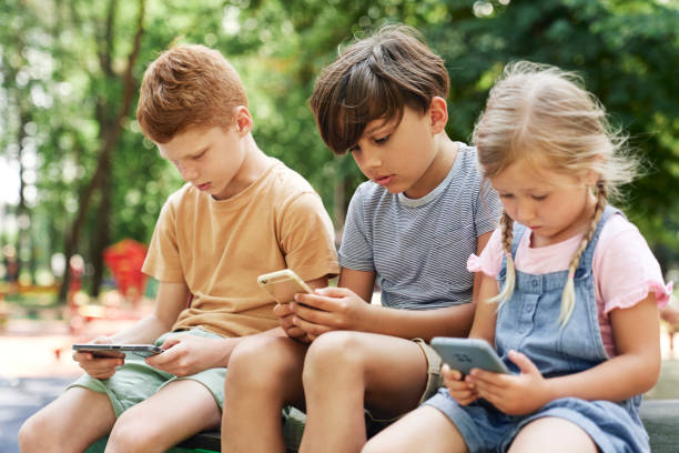 istock Group of kids using mobile phone at the playground 1413612753