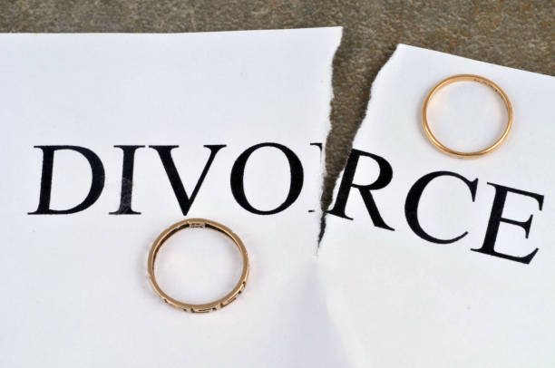 Divorce Divorce concept with torn sheet of paper and wedding rings, Family law firm Divorce forms How Long Does It Take To Get Divorced stock pictures, royalty-free photos & images