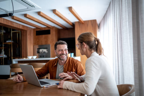 istock Mature couple talking and using the laptop at home 1413616190