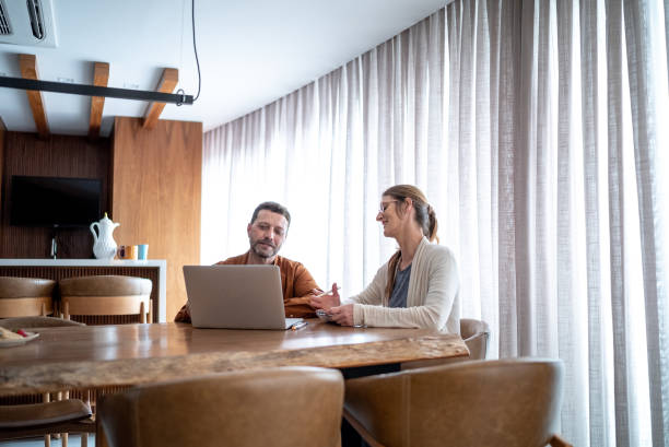 istock Mature couple talking and using the laptop at home 1413616193
