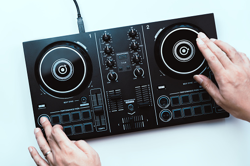 Dj Hands is scratching and mixing Digital Dj deck Controller, Topview, isolated on white.