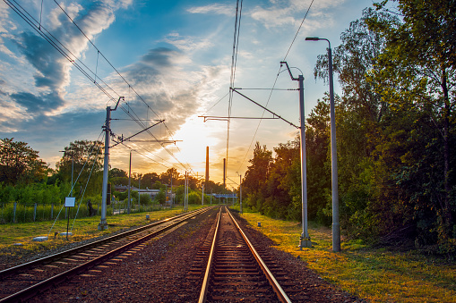 A train station in Vladivostok with passenger and freight cars by the station platform. The badly rusted tin roof vanishes into the city skyline.