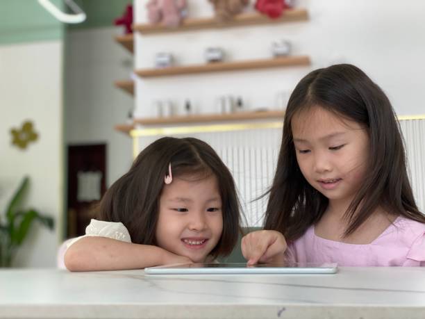 istock Two little girls using iPad to study together 1413621441