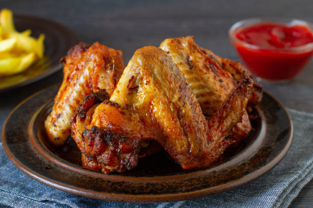 istock Grilled spicy chicken wings with ketchup on a plate on a table. 1413622707