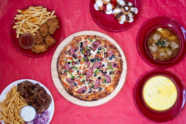 Pizza and more Pizza, sweet dumplings, fried chicken, pork chop and chips  selected restaurant dishes on a red background lota stock pictures, royalty-free photos & images