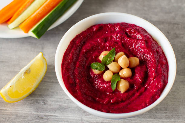 istock Roasted beet hummus with vegetables in a ceramic bowl on a gray background. 1413623348