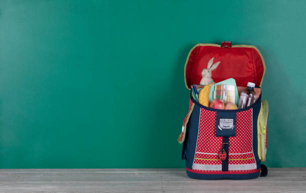 istock school bag, white wooden table and blackboard 1413624480
