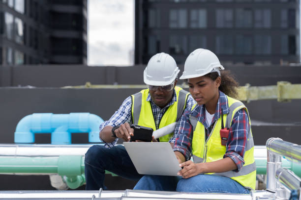 istock Group of African American engineer worker working in sewer pipes area at construction site. Male engineer and woman engineer work with laptop computer for maintenance sewer pipes 1413629182