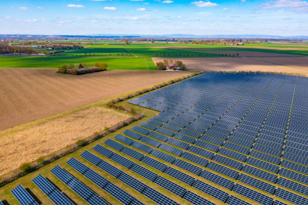 Aerial view of a solar park with many photovoltaic panels next to agricultural fields in rural Germany stock photo