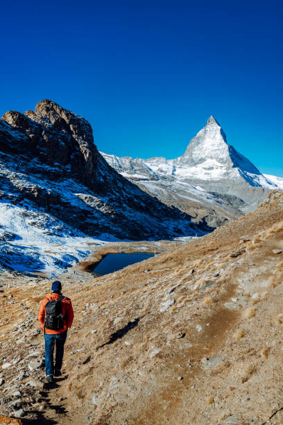istock man walking to Matterhorn mountain in Switzerland 1413632520