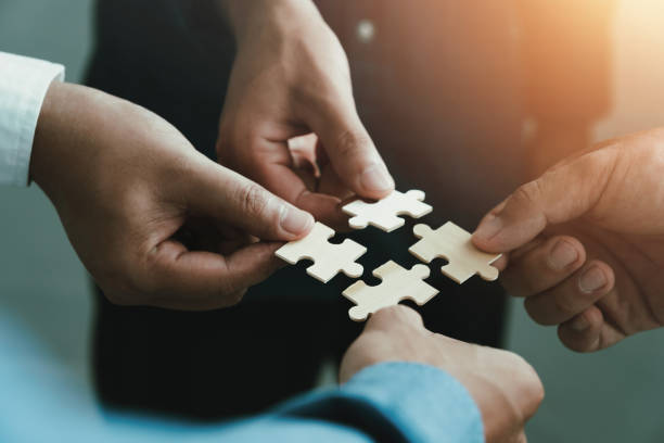 istock mobile jigsaw puzzle pieces business cooperation concept teamwork and cooperation Businessmen join a jigsaw team, charity, volunteerism, unity, teamwork. 1413633353