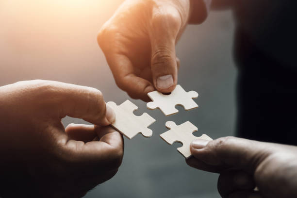 istock mobile jigsaw puzzle pieces business cooperation concept teamwork and cooperation Businessmen join a jigsaw team, charity, volunteerism, unity, teamwork. 1413633368
