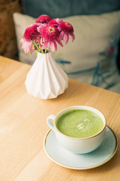 istock Close-up, a large ceramic cup with a green matcha drink on a wooden table. 1413636967
